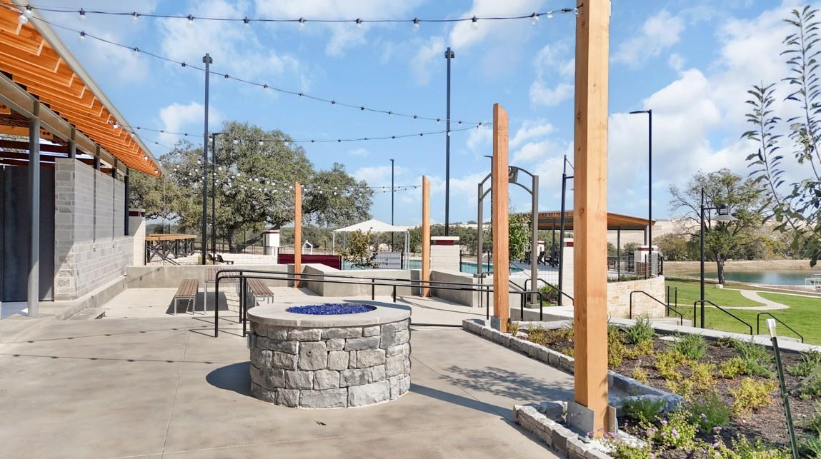 View of communal patio with a fire pit and a water view