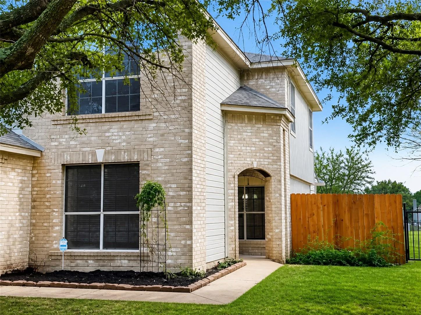 Brick and siding exterior featuring an arched entryway