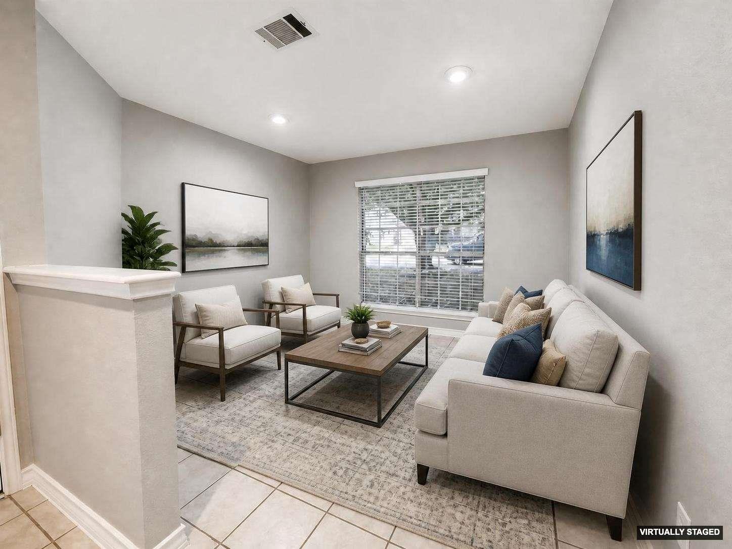Living area featuring light gray walls, recessed lighting, a large window with blinds, and tile flooring extending from the entry