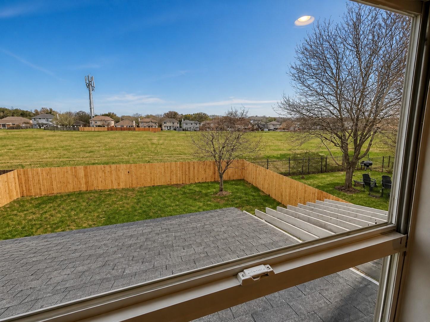 Fenced backyard with established lawn and a large shade tree