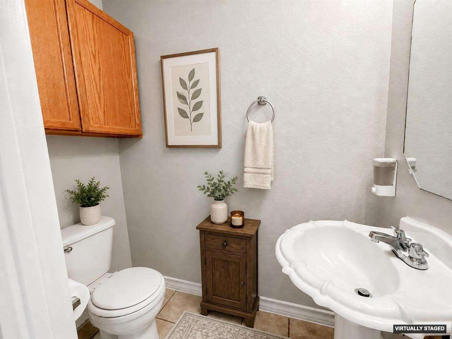 White pedestal sink with chrome faucet, complemented by a wood-finish storage cabinet
