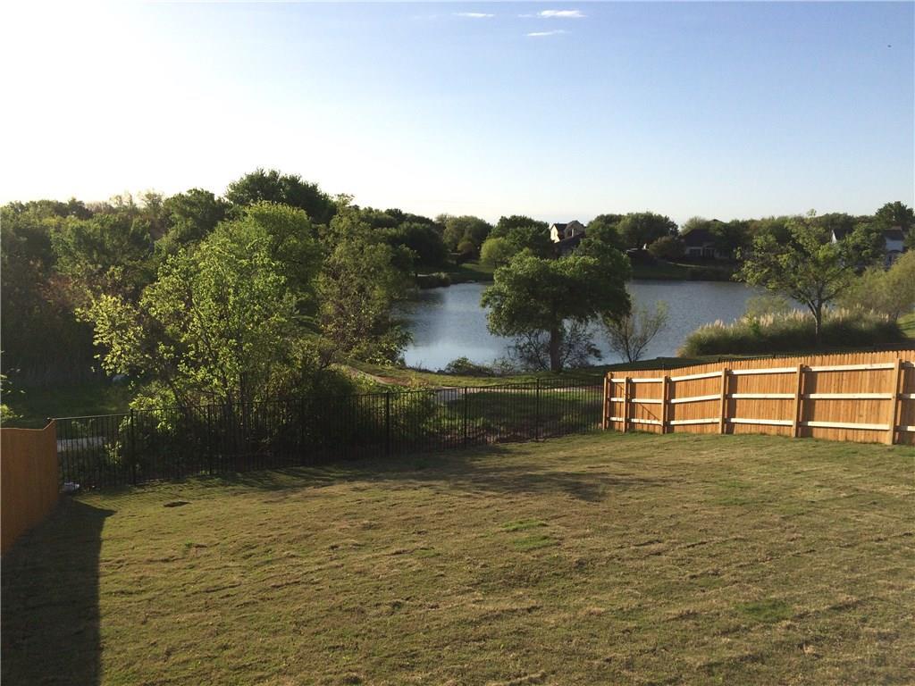 A spacious backyard provides a clear view of the peaceful lake and lush green surroundings.