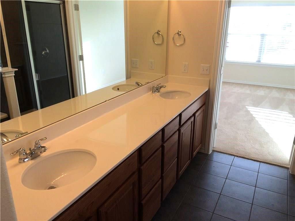 Double vanity with ample counter space and classic cabinetry, enhancing daily routines.