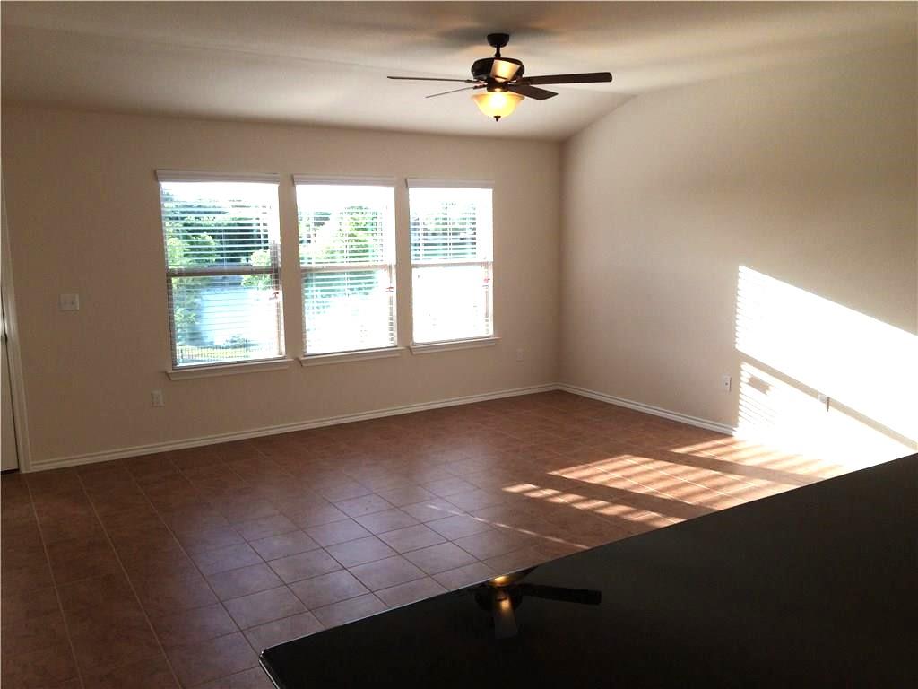 A living space offers tiled flooring and ample natural light from multiple windows.