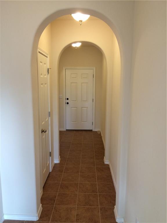 Step inside this welcoming entry featuring arched doorways and durable tile flooring.