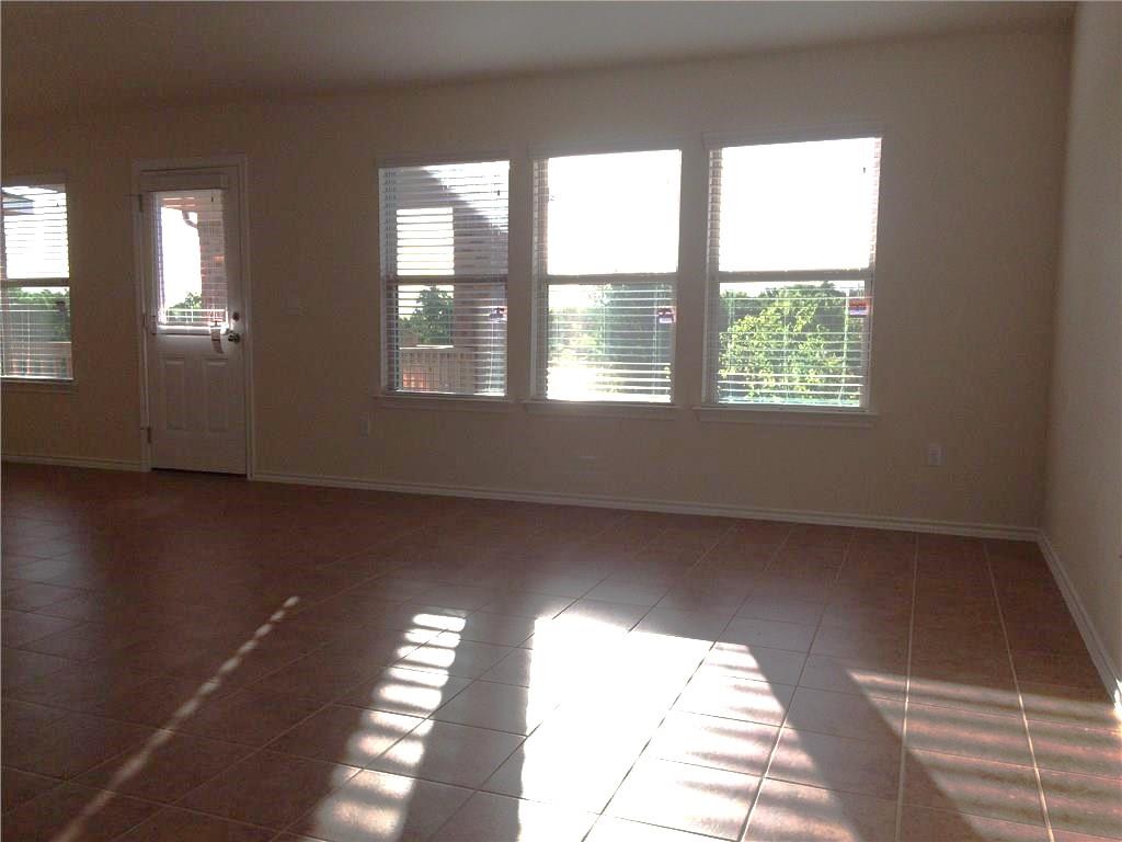 Natural light streams into this generously proportioned living area, highlighting its durable tile flooring.