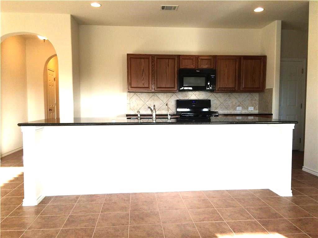 A well-appointed kitchen features dark cabinetry, modern appliances, and a spacious island.