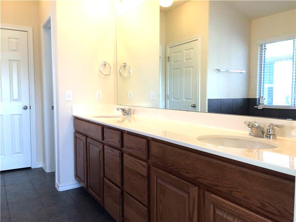 A well-lit bathroom with dual sinks and ample vanity storage.