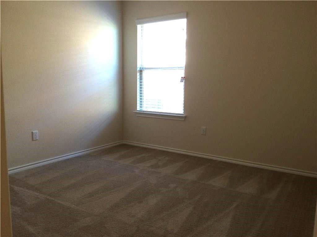 Sun-filled room awaits your personal touch, featuring plush carpeting and generous light.