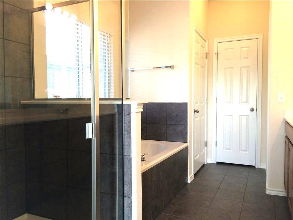 Luxurious bathroom retreat, featuring a spacious soaking tub and a sleek glass-enclosed shower.