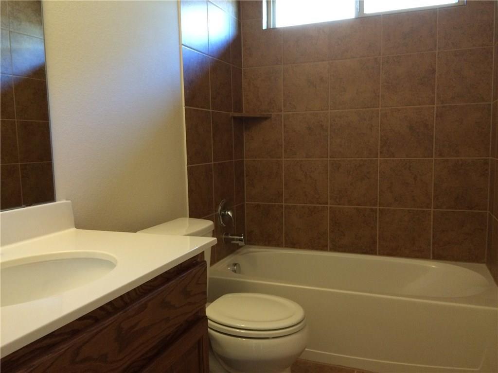 A well-appointed bathroom featuring a clean tub, toilet, and vanity with ample counter space.