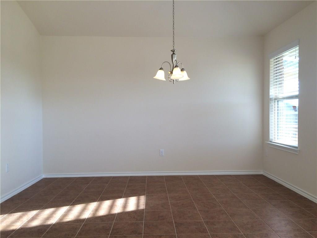 A versatile dining space awaits your personal touch, complete with elegant tile flooring and ample natural light.
