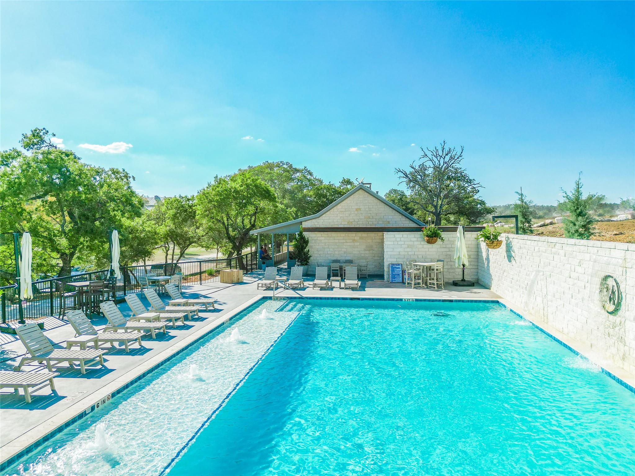 A tranquil aquatic retreat with ample lounging space beside a contemporary pool house.