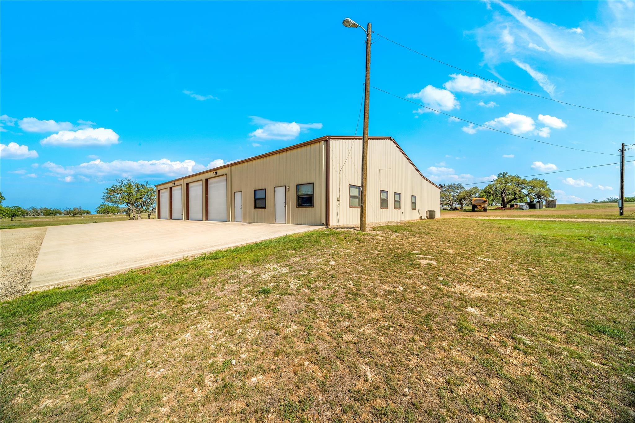 A spacious, multi-bay structure offers practical utility in a verdant, open setting.