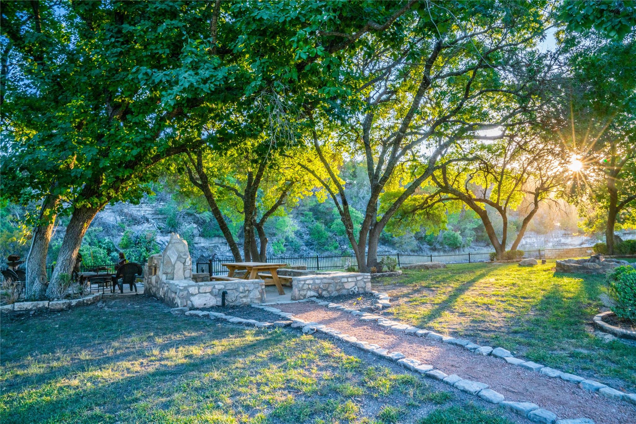 A stone-framed outdoor patio area offers a scenic river view, perfect for relaxation or entertaining.