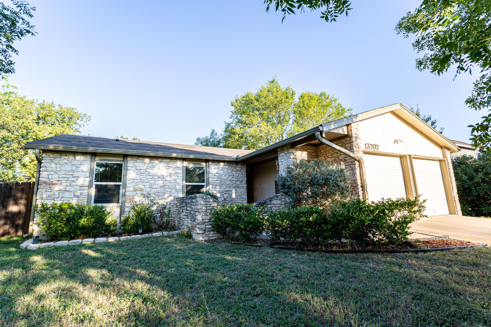 A charming stone exterior home awaits, featuring a spacious two-car garage and manicured landscaping.