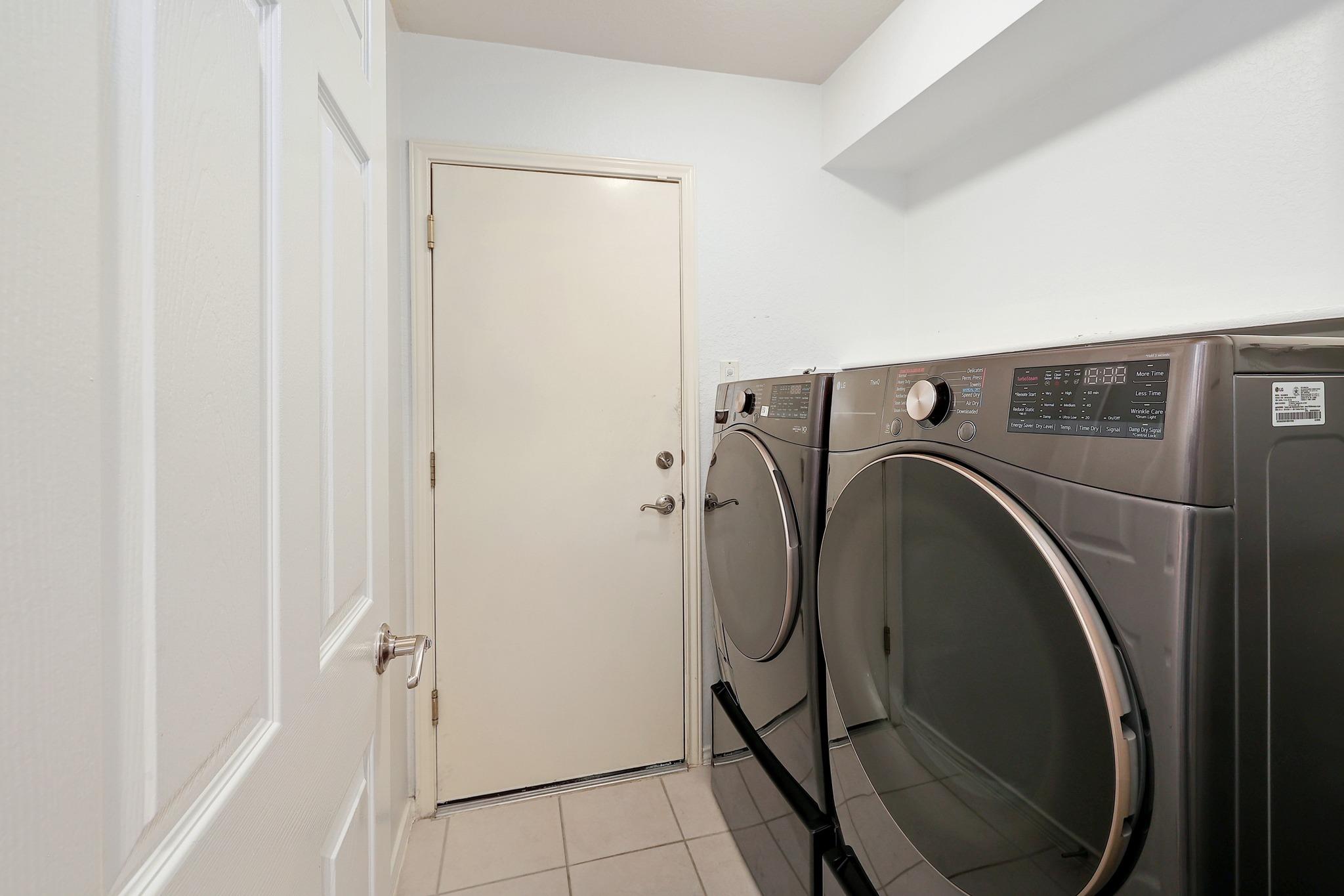 A functional laundry area with tiled flooring leads directly to the exterior entrance.