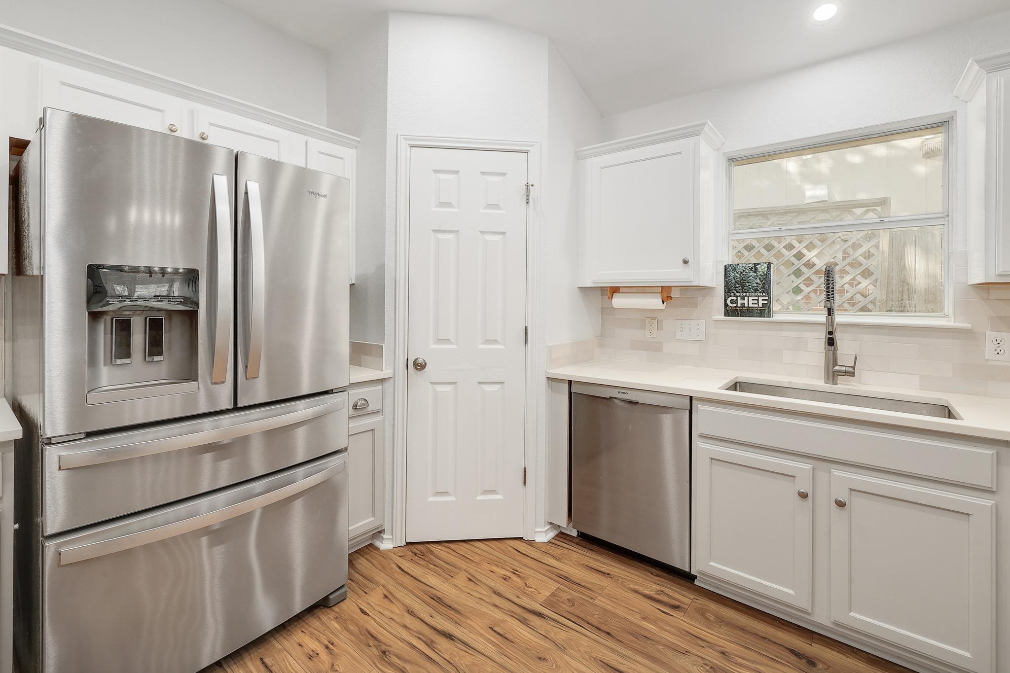 Clean white cabinetry and modern stainless steel kitchen appliances.