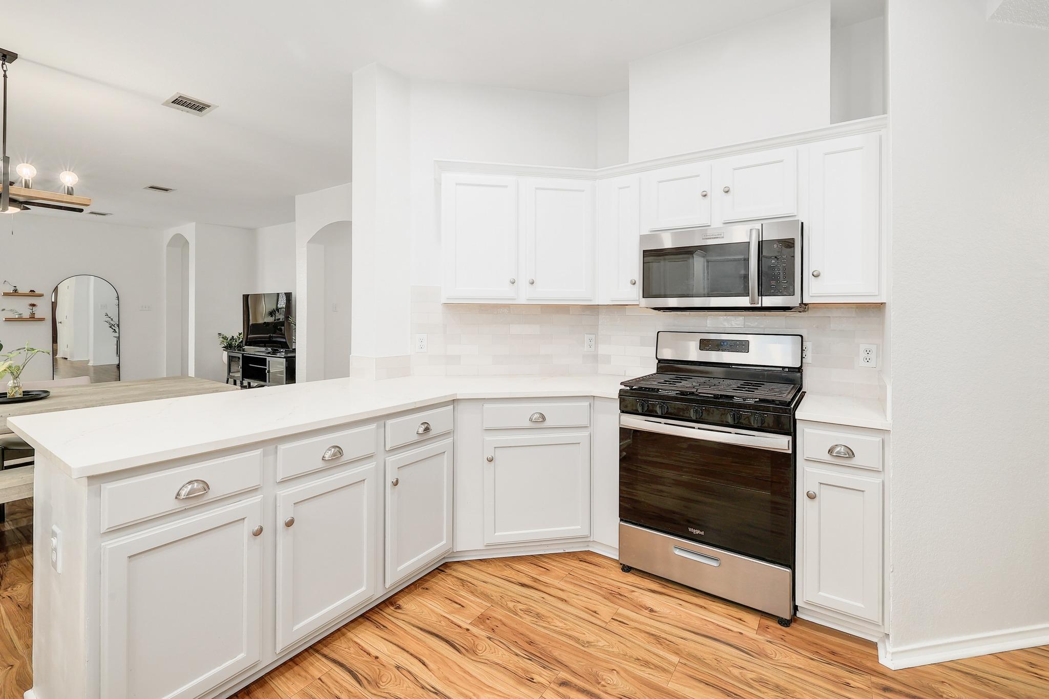 Gleaming stone countertops and classic cabinetry anchor this bright, well-appointed kitchen workspace.