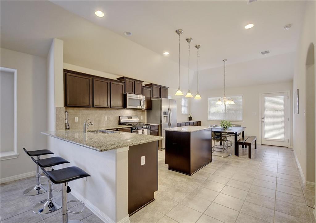 Open living space encompasses kitchen, dining and living areas.