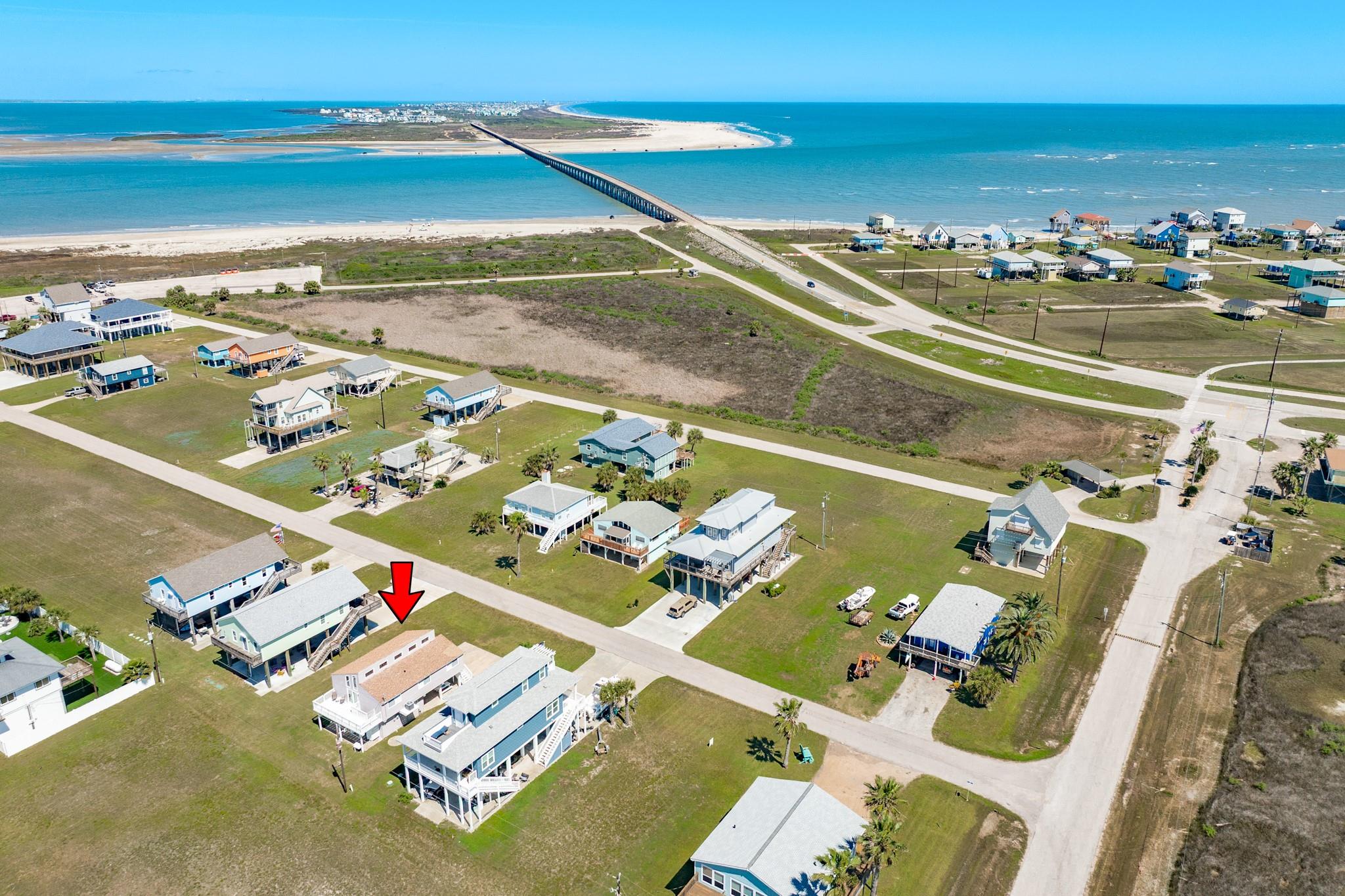 Aerial Community Overview – Situated in a well-spaced neighborhood with nearby water access points, offering a blend of privacy and convenience to coastal amenities.