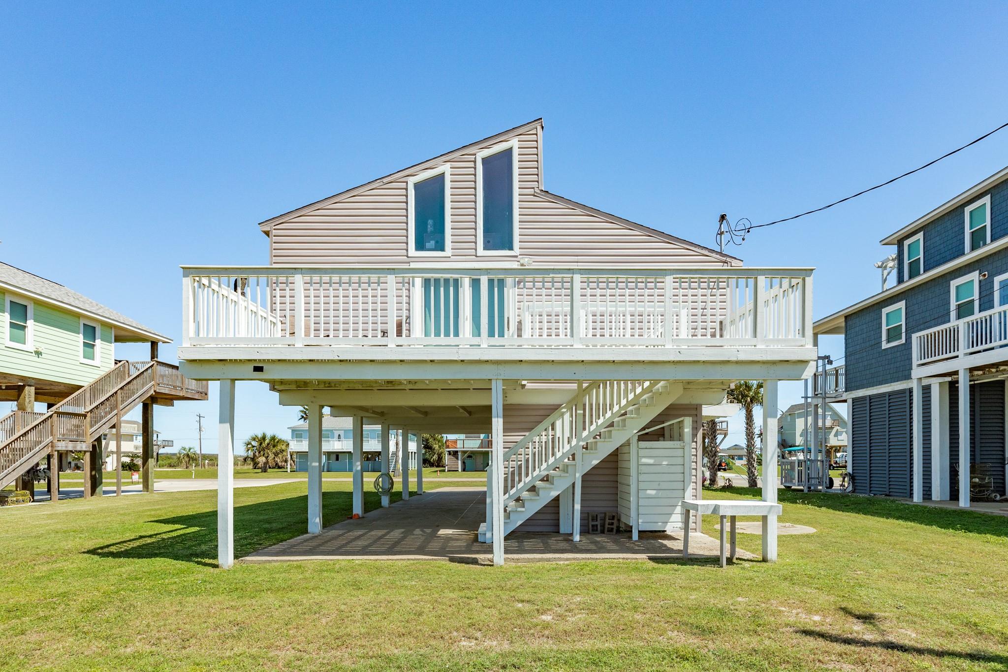 Rear Exterior – Elevated design continues at the back of the home with a full-width upper deck, offering additional outdoor living space and easy access from the main level.