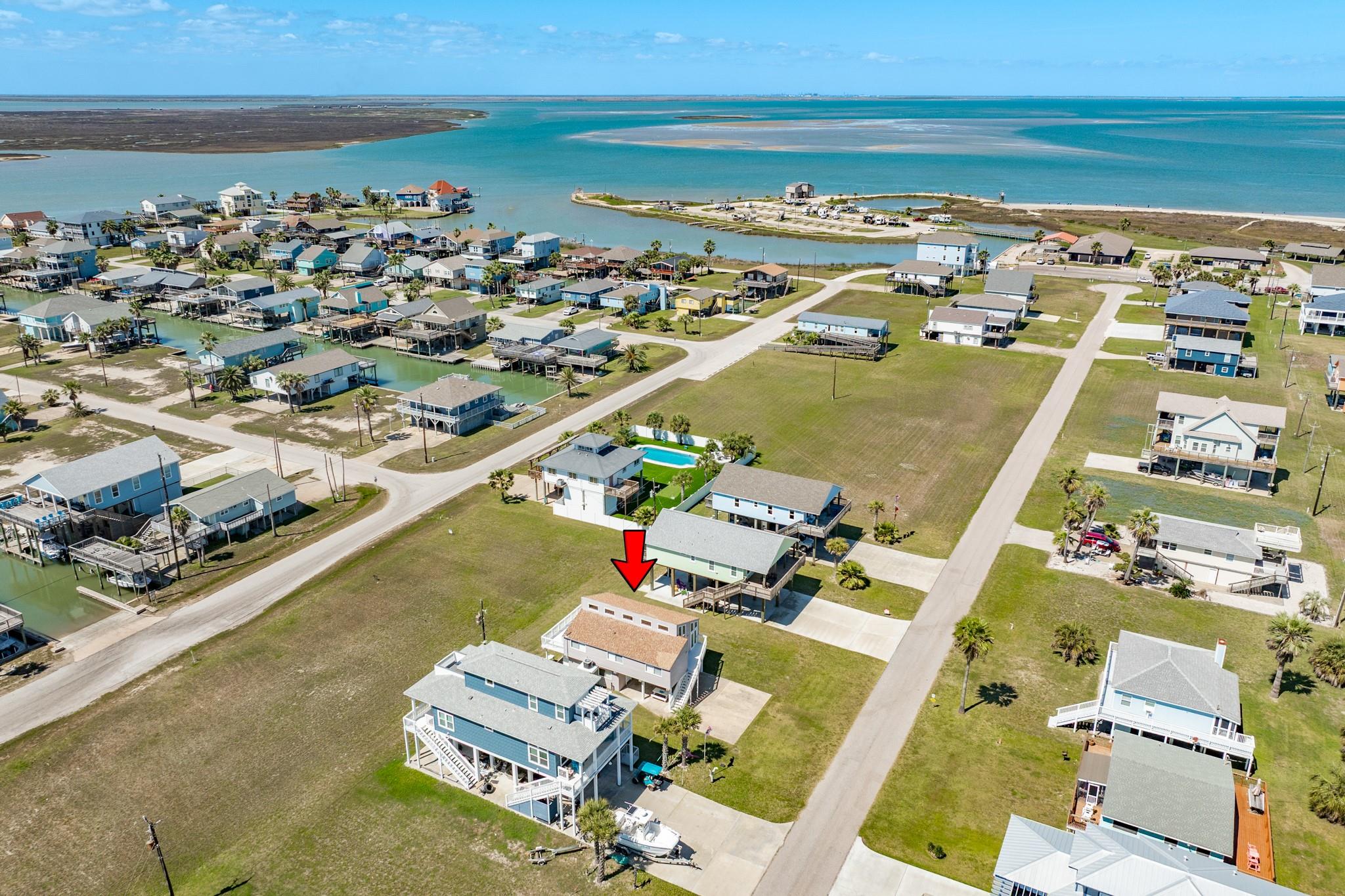Aerial Coastal View – Enjoy nearby access to sandy shoreline and expansive water views, with a long pier extending toward the beach area—perfect for fishing or sunset walks.