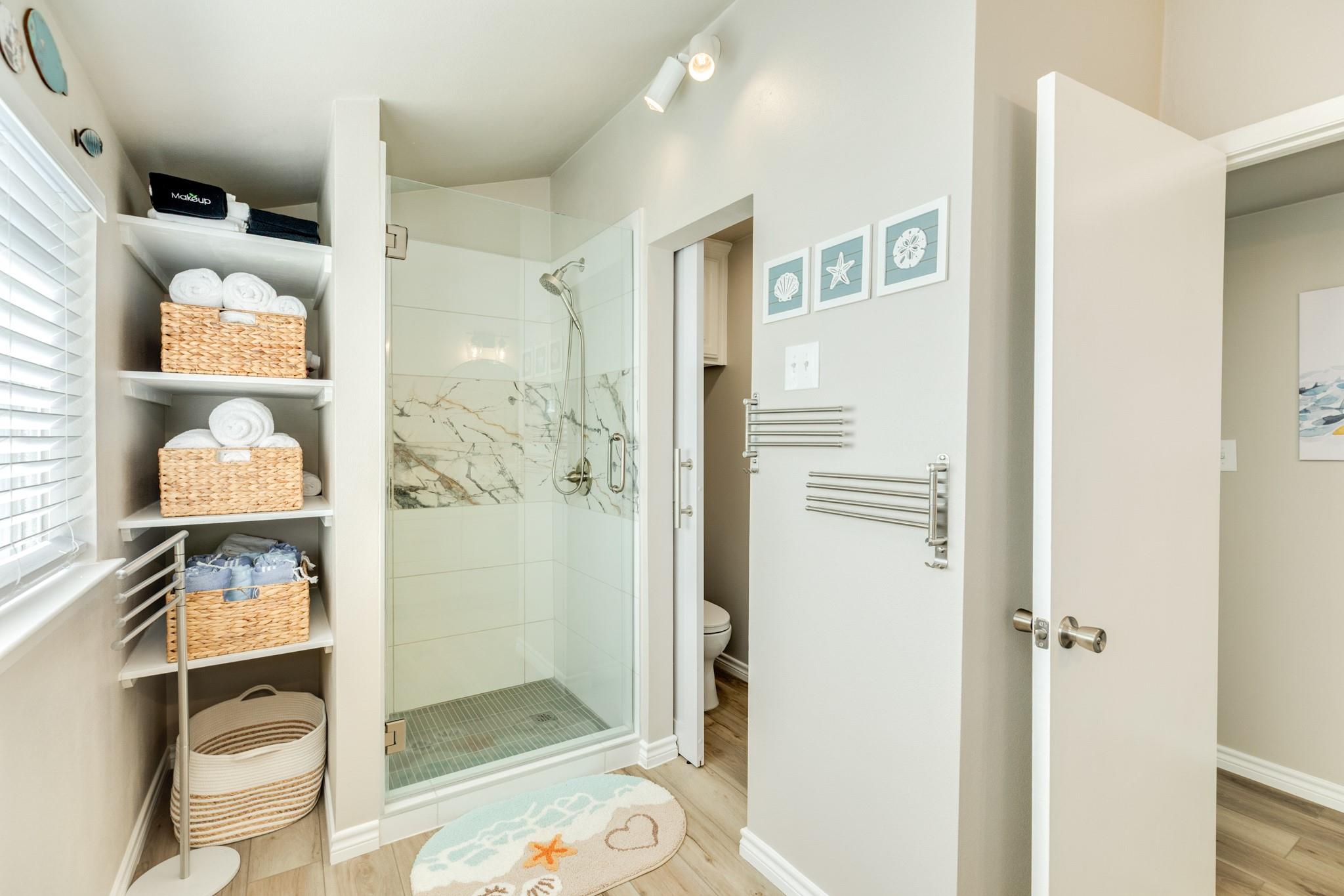 Bathroom (Shower) – Walk-in shower with glass enclosure and decorative tile accents, creating a fresh and functional space.