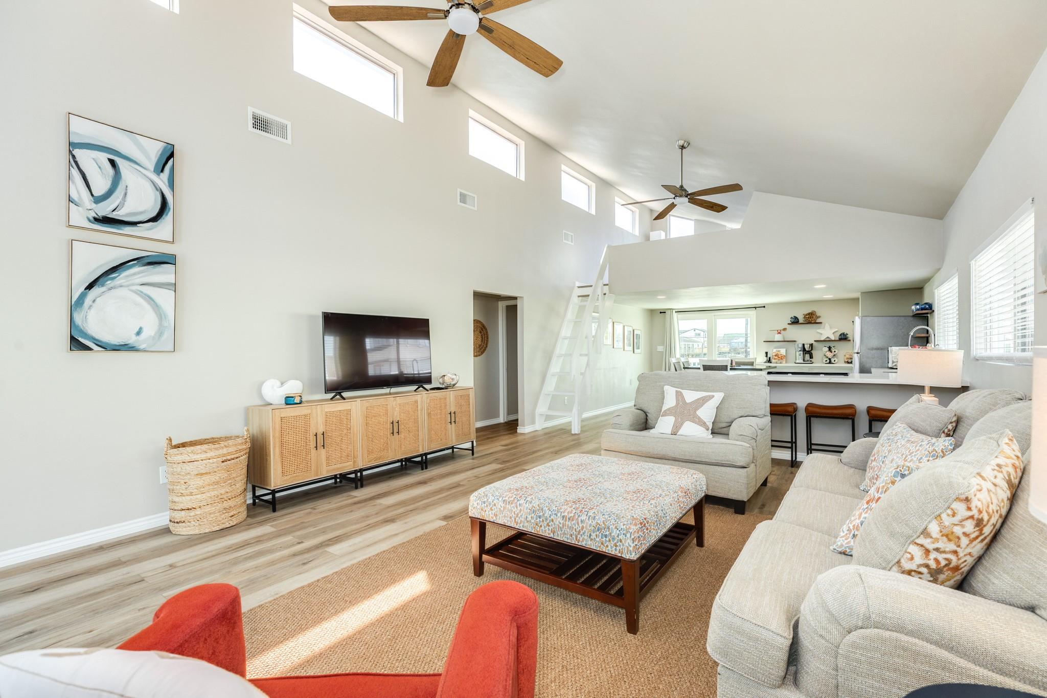 Living Room with Loft Access – Dramatic ceiling height complemented by upper-level loft access and clerestory windows that enhance natural light throughout the space.