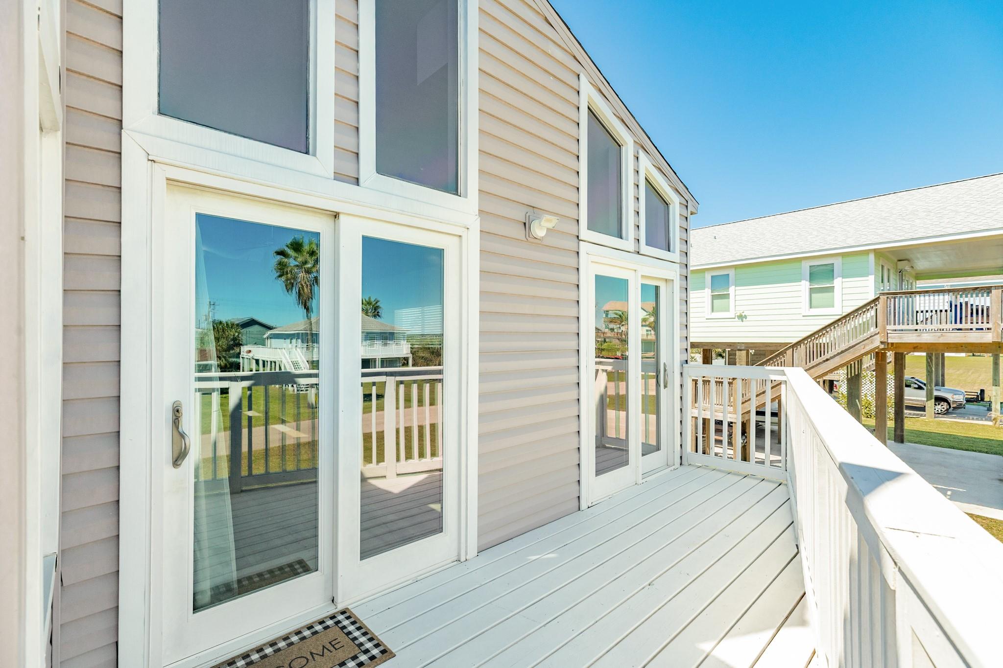 Upper Deck Entry – Welcoming deck entrance with double glass doors and large windows, allowing for seamless indoor-outdoor flow.