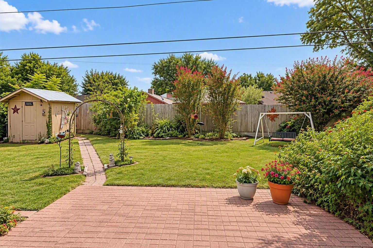 Lush backyard gardens with storage shed and exterior sitting area