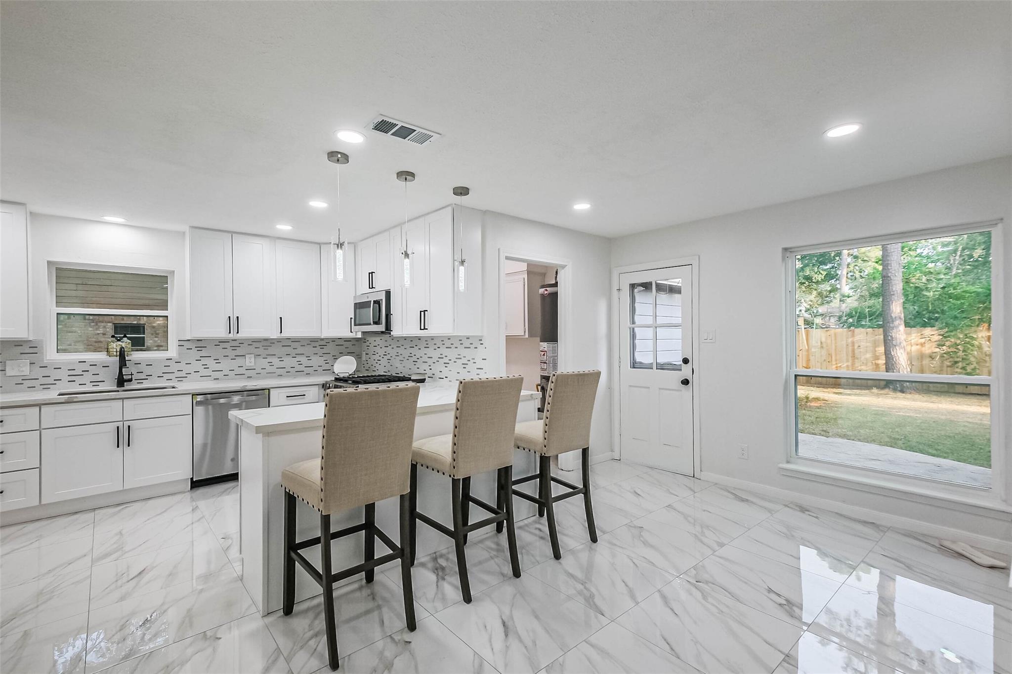 The breakfast nook enjoys lovely views of the backyard. The kitchen high counter has seating for 3 / 4 high chairs.