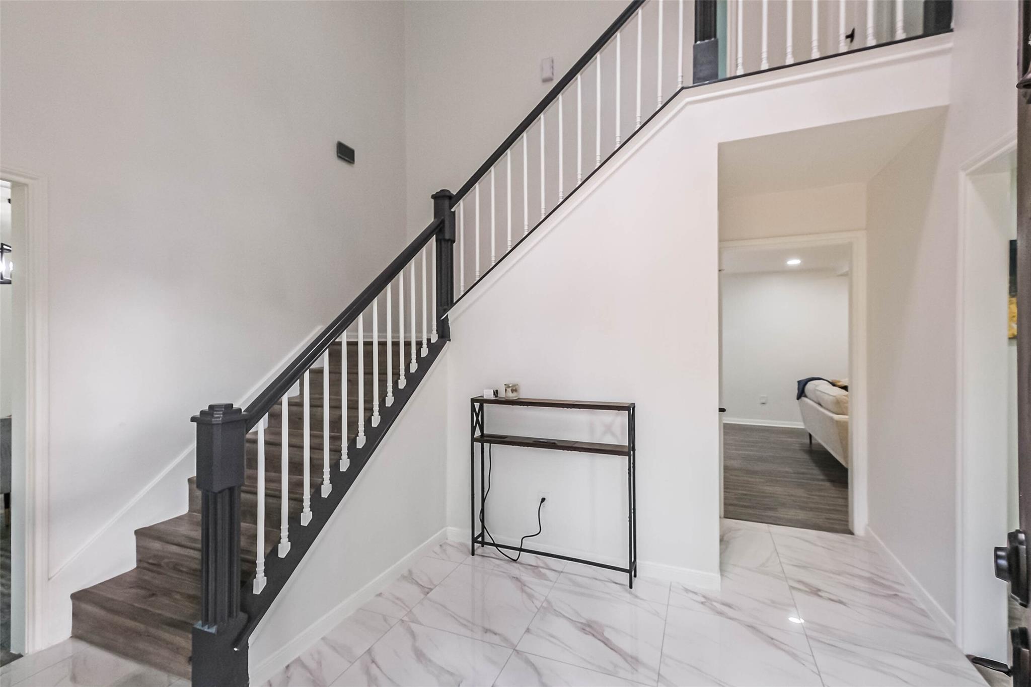 Really lovely hallway with high ceilings, designer light fixture and new floor tiles.